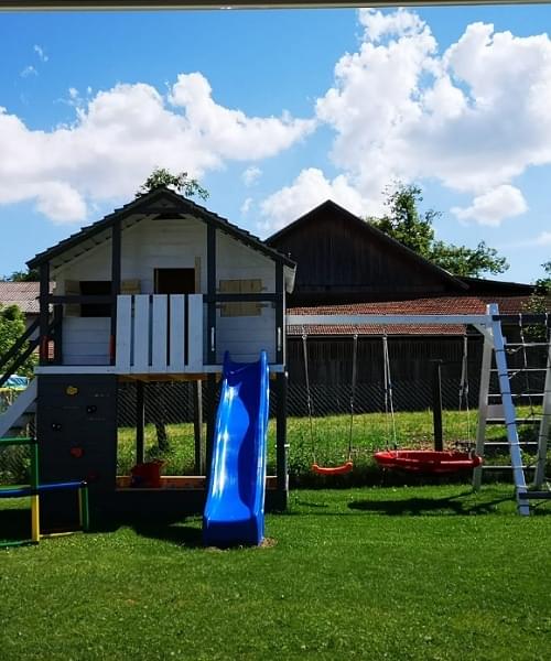Spielhaus mit Schaukel im eigenen Garten